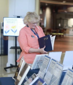 Joan Darby ’74 browses books during the alumni author meet-and-greet at 2024’s Reunion Weekend. Photo by Karen Pearlman.